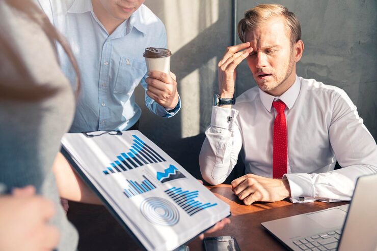 Investing Mistakes for Beginner Investors reviewing stock market charts and financial planning notes at a desk.
