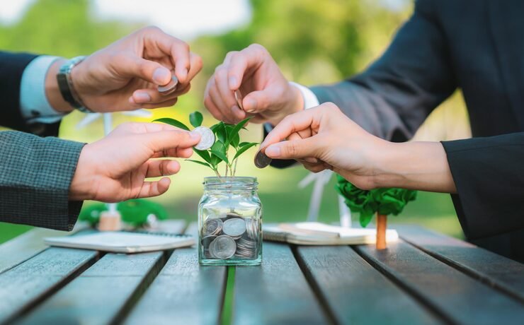 Investing vs saving comparison with a savings jar, coins, financial planning notebook and investment charts
