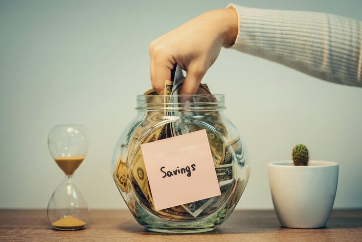 Simple ways to save more money with a budget notebook, savings jar, calculator and financial planning tools.